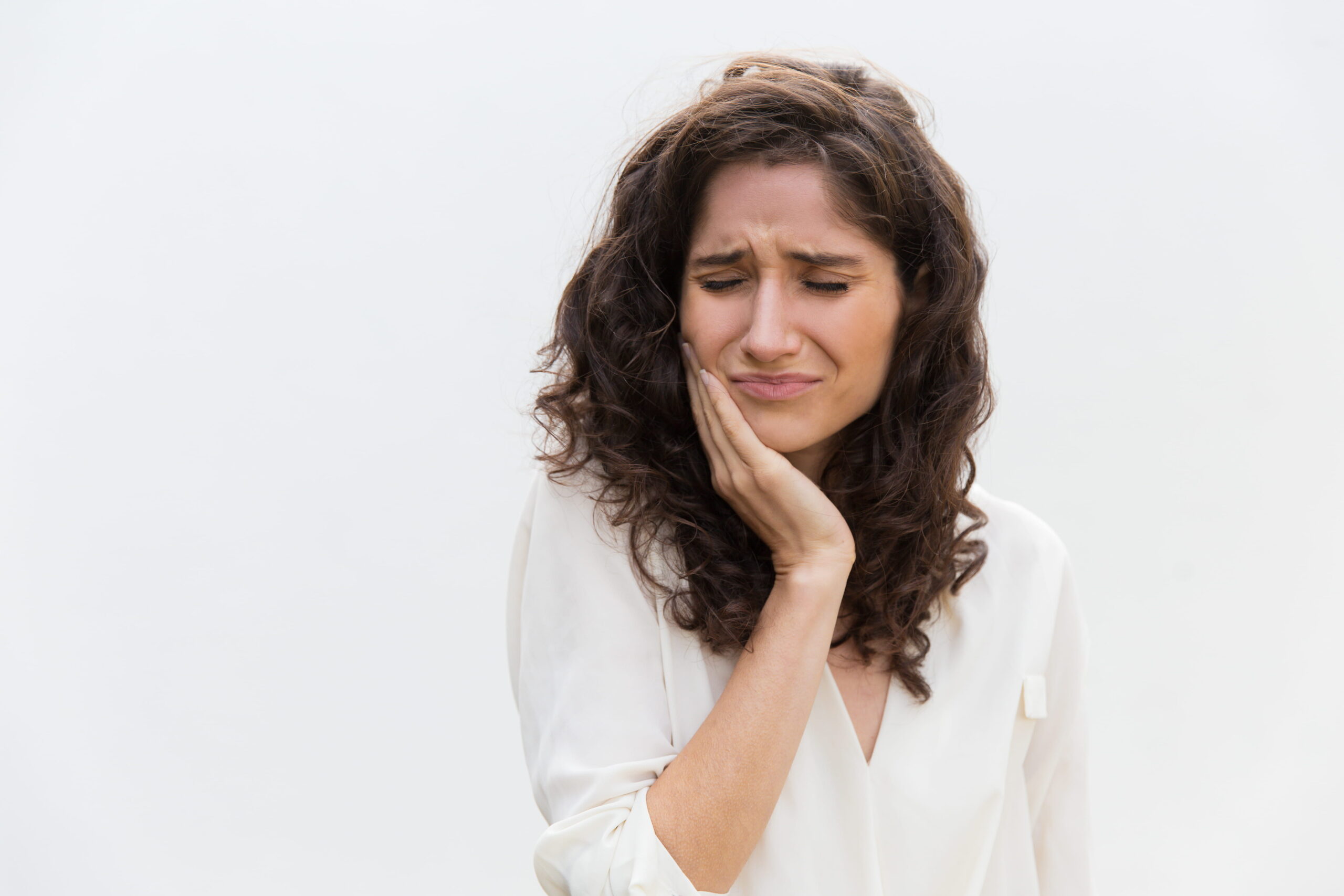 Woman experiencing tooth sensitivity pain, treated at Calista Dental Mumbai